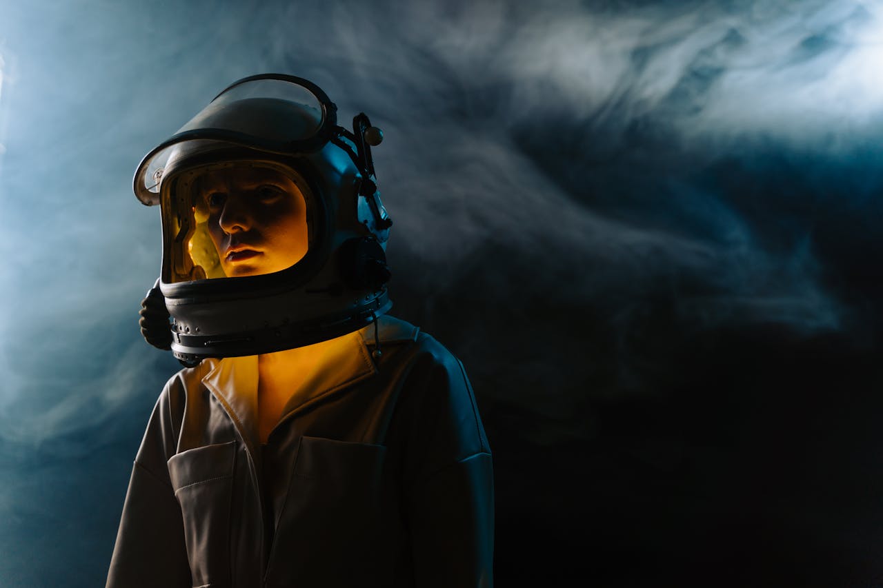 our-story-02 A dramatic portrait of an astronaut in a dimly lit, smoky environment, exuding mystery and exploration.